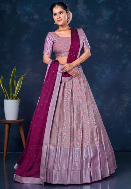 Woman wearing a traditional pink and purple lehenga choli with dupatta