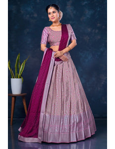 Woman wearing a traditional pink and purple lehenga choli with dupatta