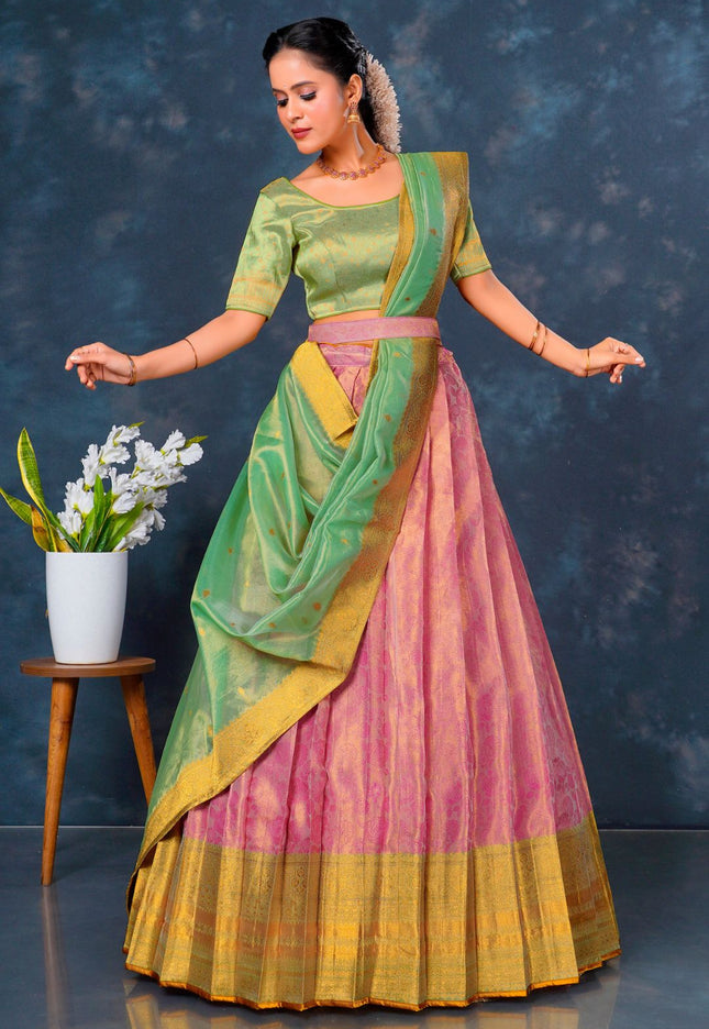 Woman in a traditional green and pink lehenga choli with dupatta