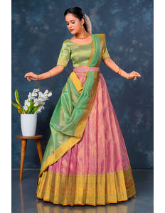 Woman in a traditional green and pink lehenga choli with dupatta