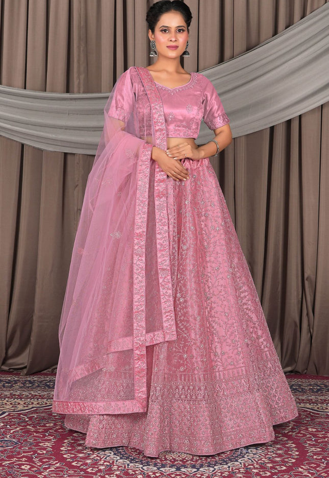 Woman wearing a pink traditional outfit with a matching dupatta
