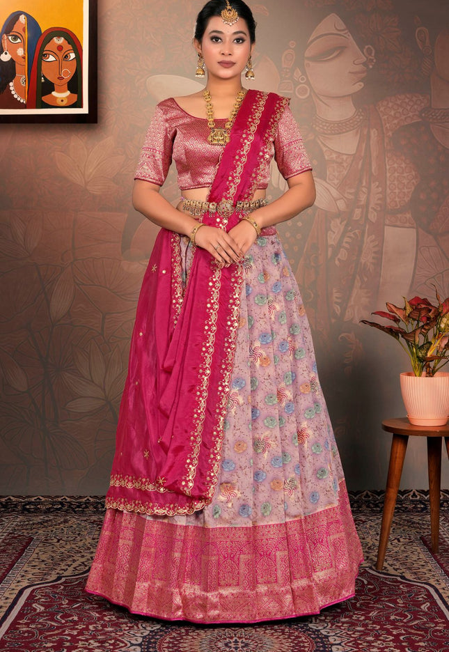 Woman in a traditional pink and multicolored lehenga choli with dupatta