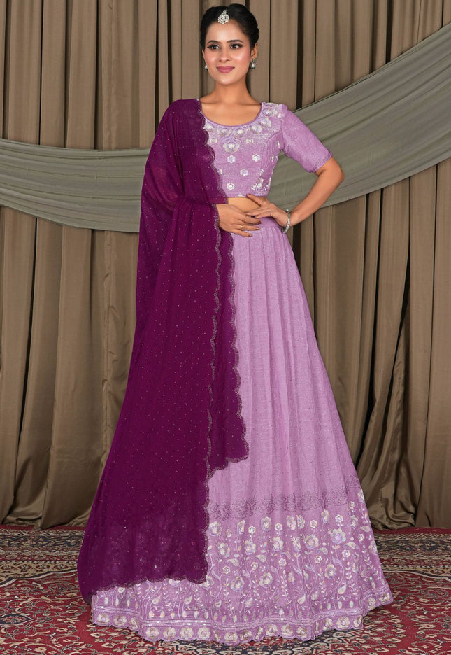 Woman wearing a purple and pink traditional outfit with a matching dupatta