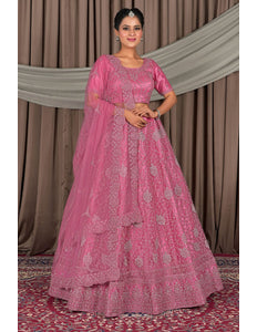 Woman wearing a pink traditional outfit with intricate designs