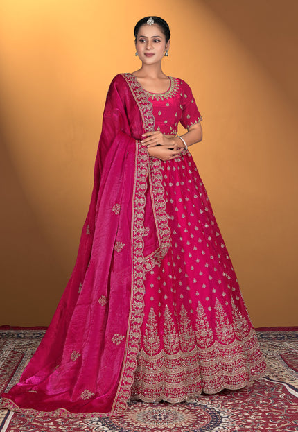 Woman wearing a pink embroidered traditional lehenga with matching blouse