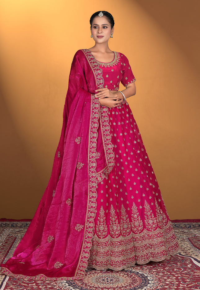 Woman wearing a pink embroidered traditional lehenga with matching blouse