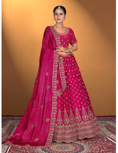 Woman wearing a pink embroidered traditional lehenga with matching blouse