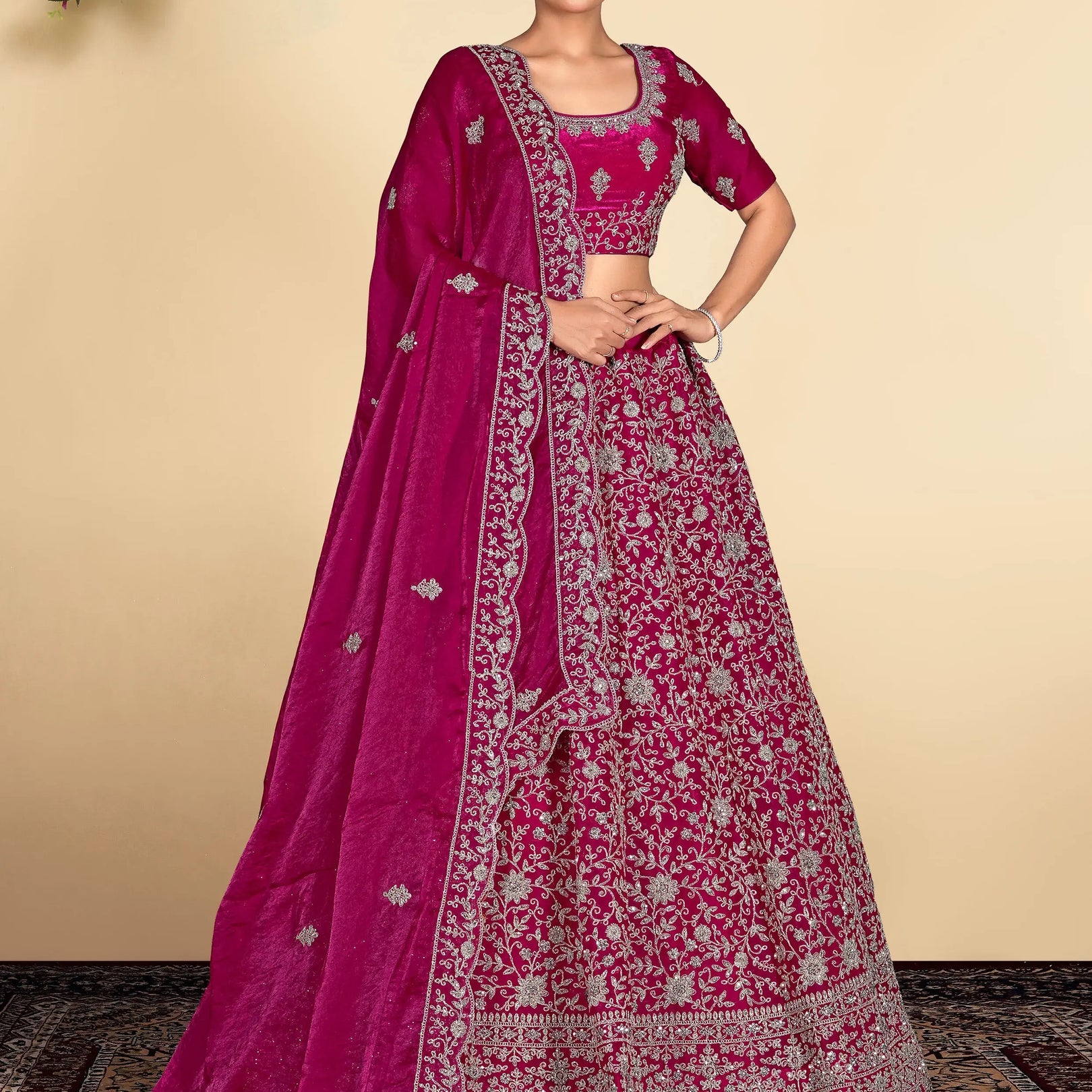 Woman wearing a traditional pink embroidered lehenga with a matching blouse
