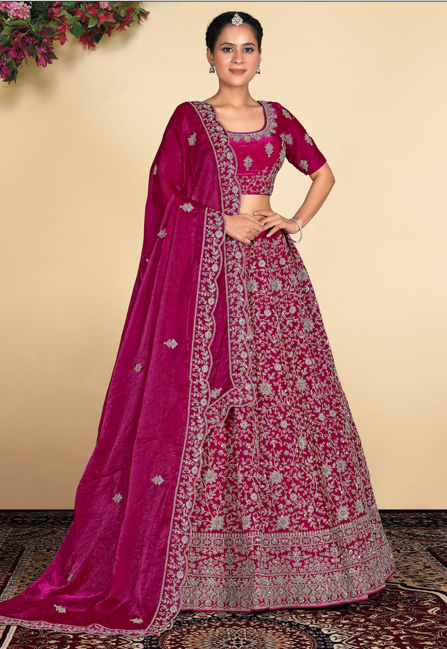 Woman wearing a traditional pink embroidered lehenga with a matching blouse