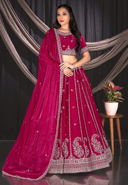 Woman in a vibrant pink traditional outfit with intricate designs.