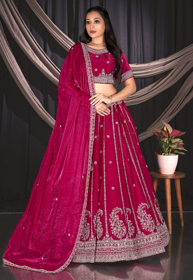 Woman in a vibrant pink traditional outfit with intricate designs.