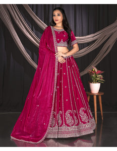 Woman in a vibrant pink traditional outfit with intricate designs.
