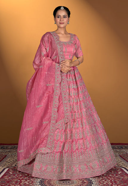 Woman wearing a pink traditional outfit with intricate patterns