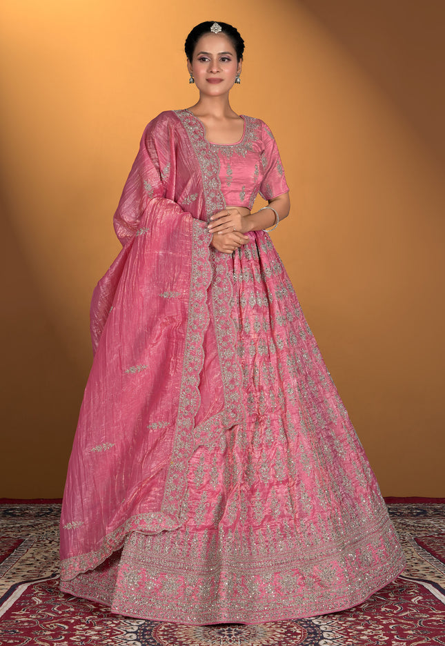 Woman wearing a pink traditional outfit with intricate patterns
