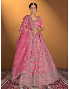 Woman wearing a pink traditional outfit with intricate patterns