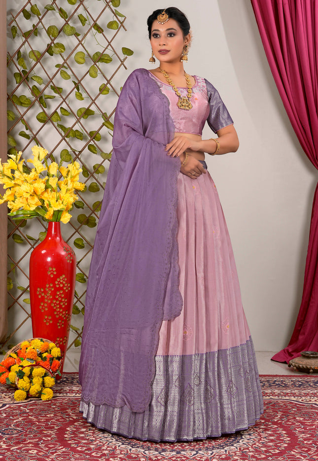 Woman in a traditional outfit with a purple and pink lehenga choli with dupatta
