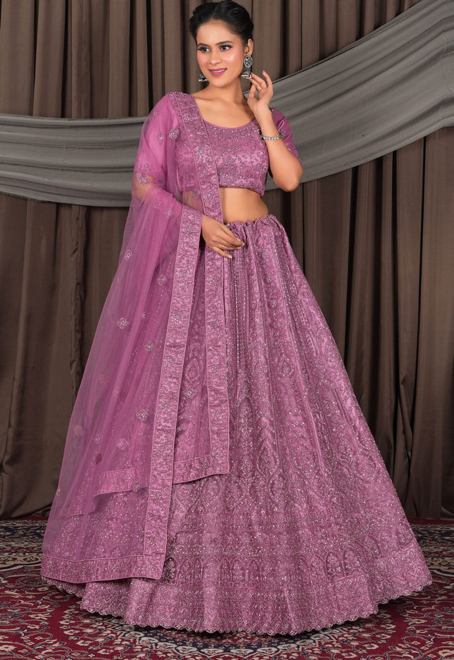 Woman wearing a traditional pink outfit with a matching dupatta