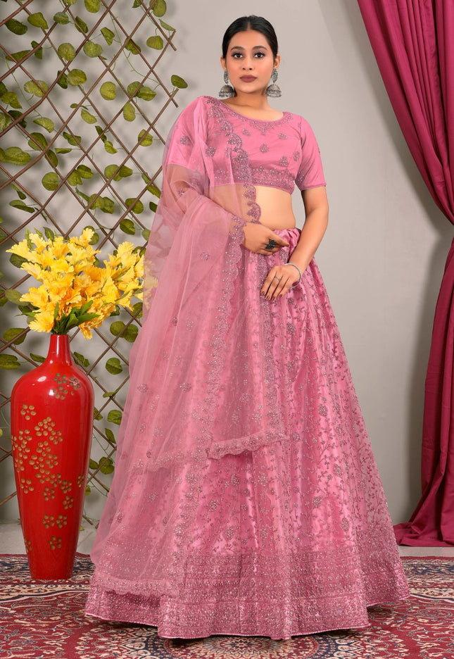 Woman in a pink traditional lehenga choli with matching dupatta