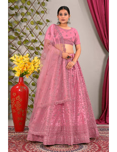 Woman in a pink traditional lehenga choli with matching dupatta