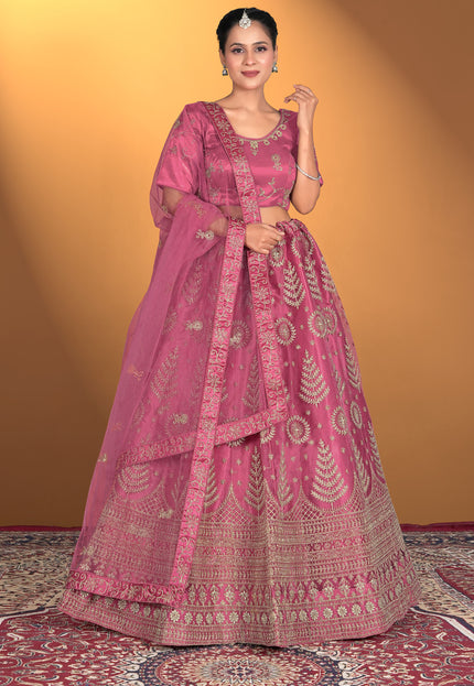 Woman wearing a pink traditional outfit with intricate patterns