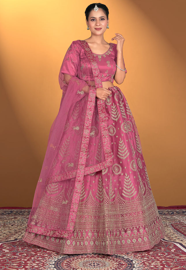 Woman wearing a pink traditional outfit with intricate patterns