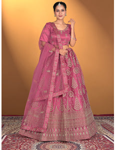 Woman wearing a pink traditional outfit with intricate patterns