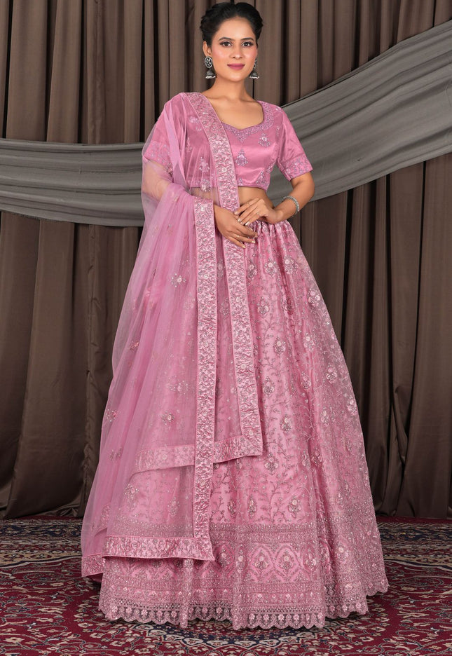 Woman wearing a pink traditional outfit with a matching dupatta