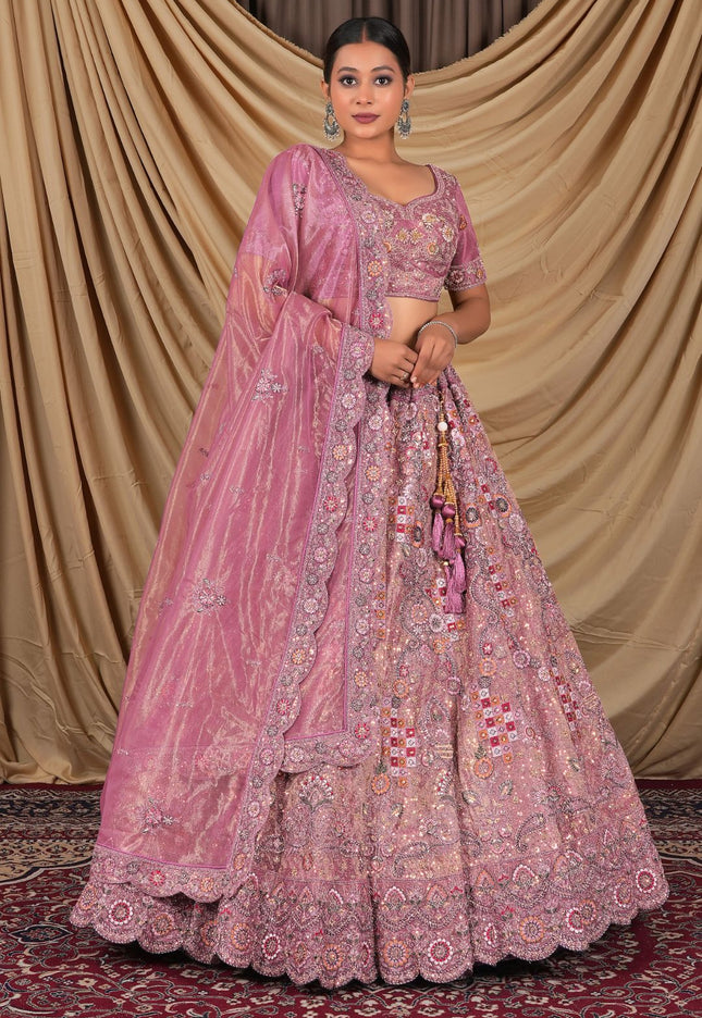 Woman wearing a pink embroidered traditional lehenga choli