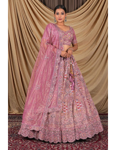 Woman wearing a pink embroidered traditional lehenga choli