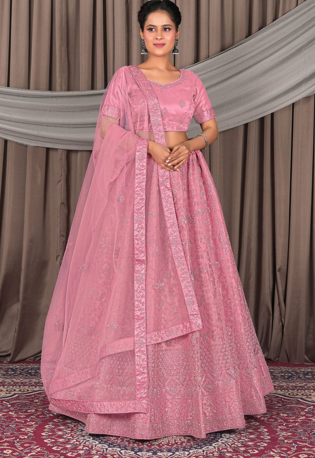 Woman wearing a pink traditional outfit with a matching dupatta