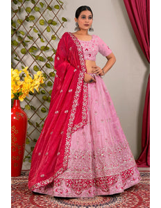 Woman wearing a pink and red traditional lehenga choli