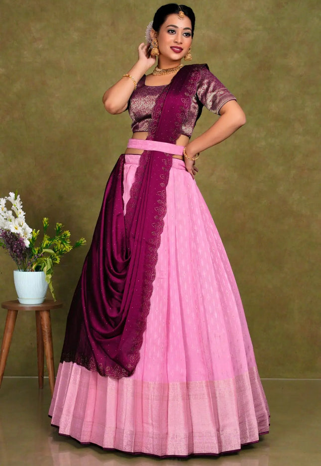 Woman wearing a pink and purple traditional outfit with a draped lehenga choli