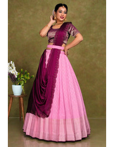 Woman wearing a pink and purple traditional outfit with a draped lehenga choli