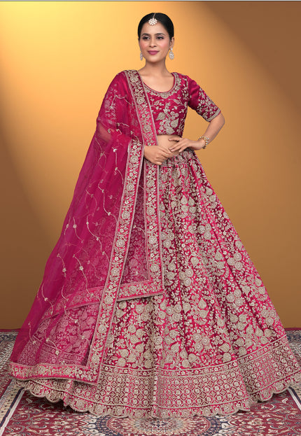 Woman wearing a traditional pink embroidered outfit with a matching dupatta