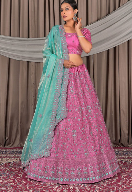 Woman wearing a pink traditional outfit with a sea green dupatta