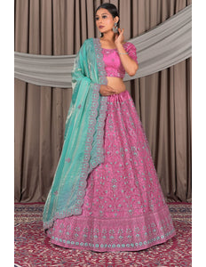 Woman wearing a pink traditional outfit with a sea green dupatta
