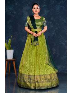 Woman wearing a green traditional half saree with dupatta