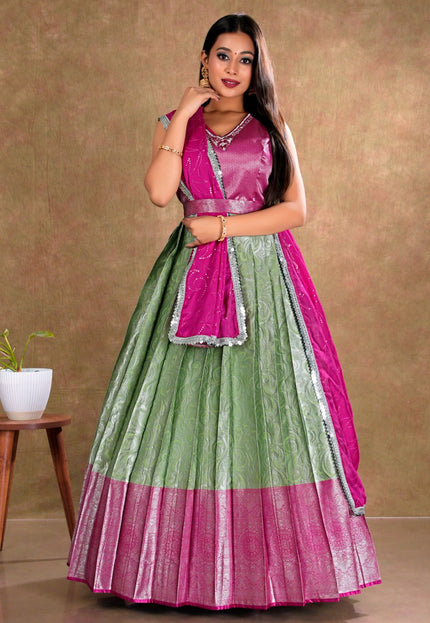 Woman wearing a green and pink traditional gown with dupatta