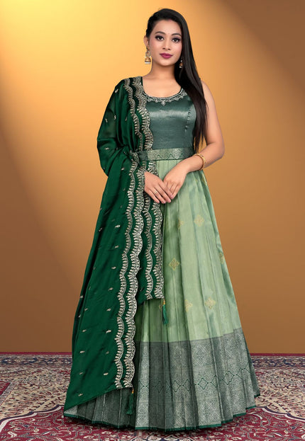 Woman wearing a green traditional outfit with a matching dupatta