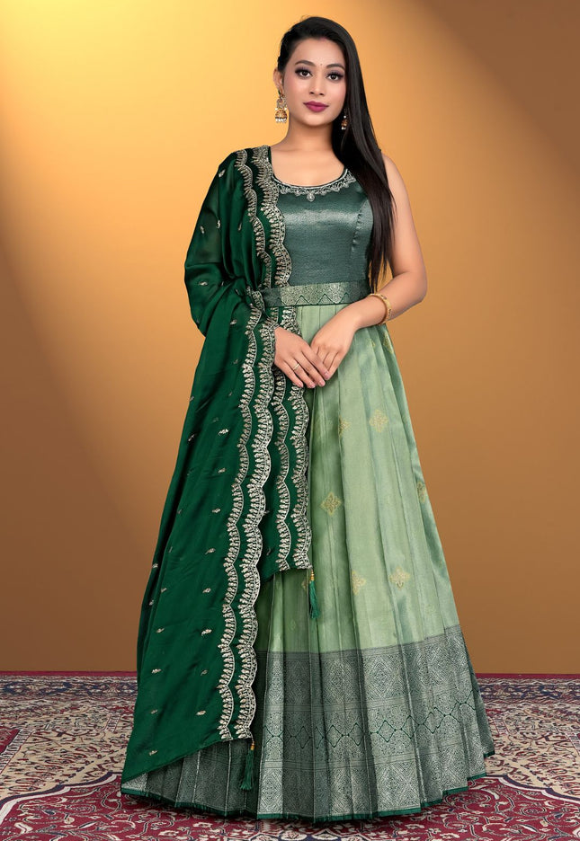 Woman wearing a green traditional outfit with a matching dupatta