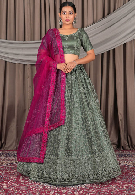 Woman wearing a pista traditional outfit with a pink dupatta