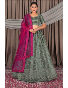 Woman wearing a pista traditional outfit with a pink dupatta
