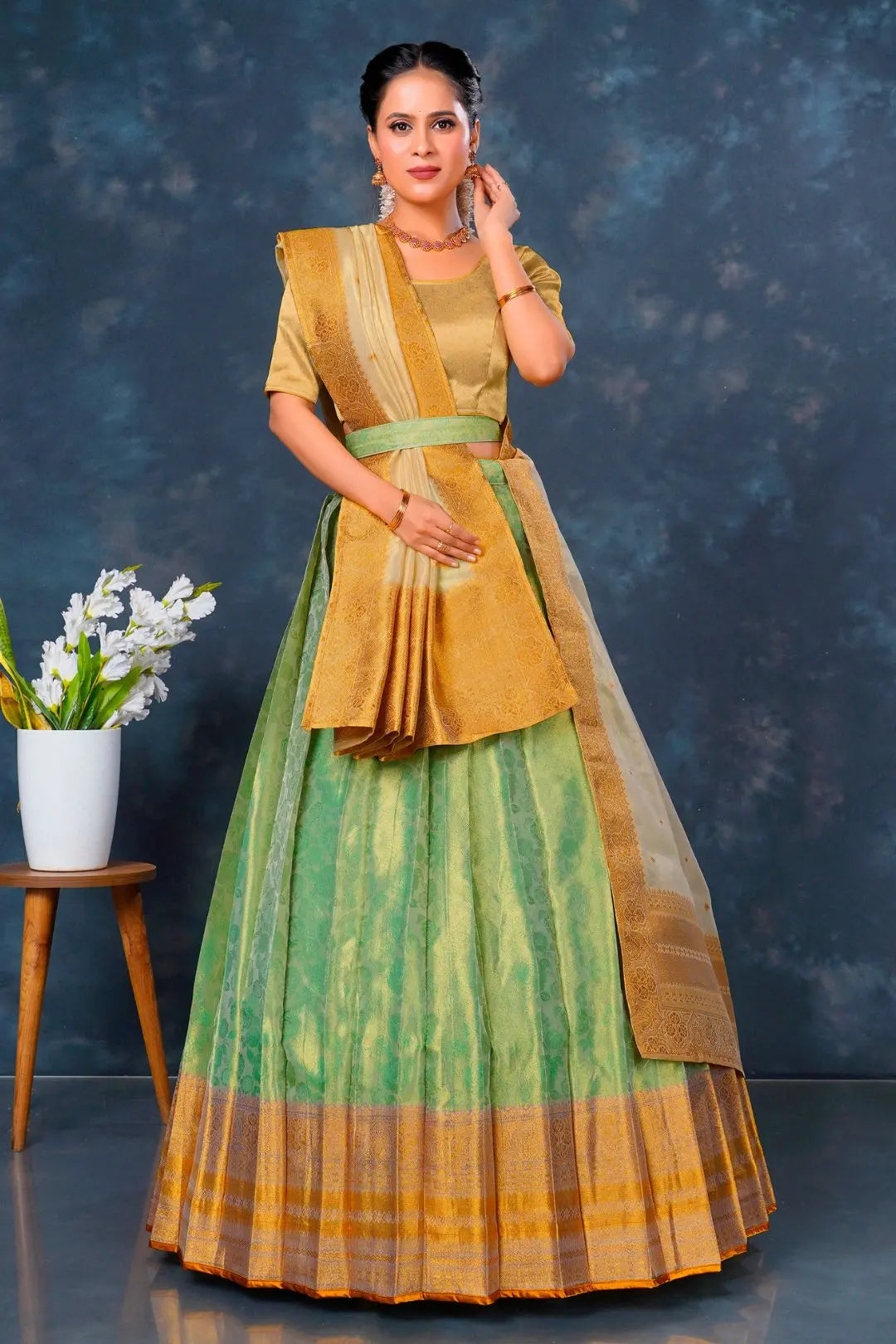 Woman wearing a traditional green and yellow lehenga choli with dupatta