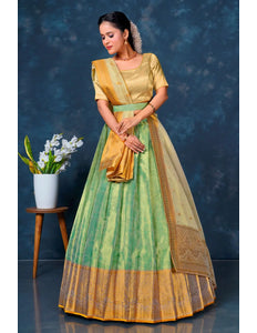Woman in a green and yellow traditional lehenga choli with dupatta