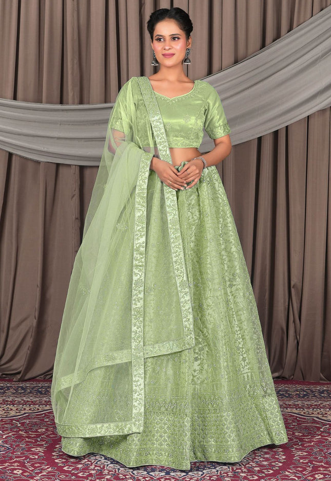 Woman wearing a green traditional outfit with a matching dupatta