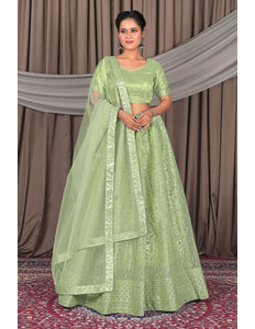 Woman wearing a green traditional outfit with a matching dupatta
