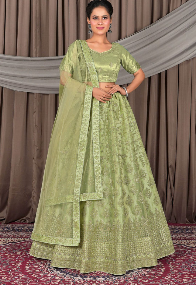 Woman wearing a green traditional outfit with a matching dupatta