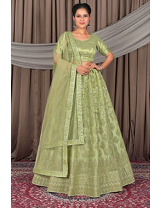 Woman wearing a green traditional outfit with a matching dupatta