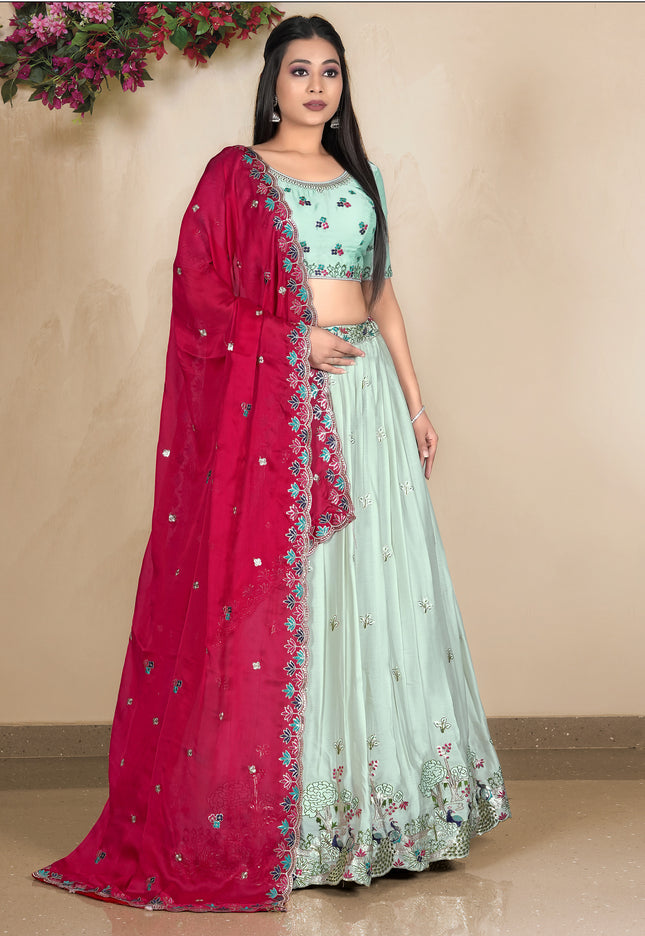 Woman wearing a traditional outfit with a pink and pista lehenga