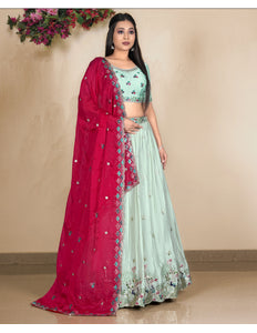 Woman wearing a traditional outfit with a pink and pista lehenga